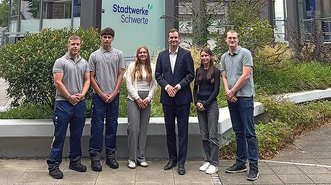 Bild von Sebastian Kirchmann, Geschäftsführer der Stadtwerke Schwerte, gemeinsam mit für Auszubildenden vor dem Gebäude der Stadtwerke Schwerte