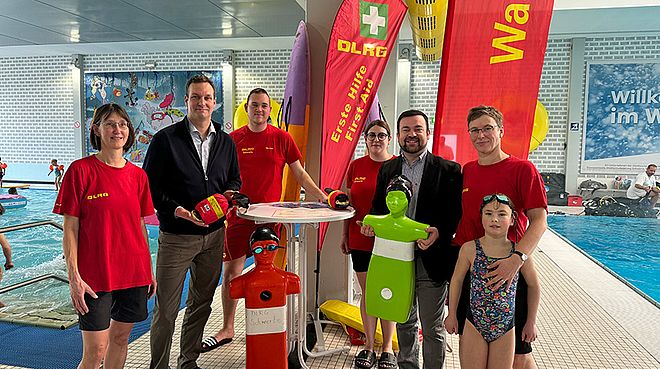 Eine Gruppe von Menschen im Stadtbad an einem Infostand der DLRG.