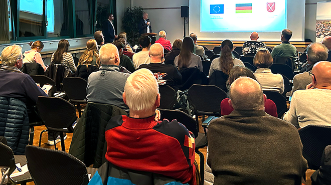 Das Bild zeigt einen Blick in den Saal mit den Besuchern.