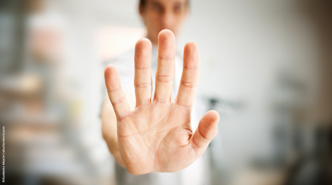 Eine Hand wird stoppend hochgehalten als Symbolbild, um keine Betrüger ins Haus zu lassen.