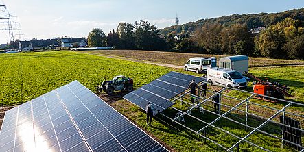Es werden Solarmodule auf der großen Freiflächen-Photovoltaikanlage angebracht.