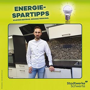 Ein Mann steht in der Küche neben dem energiesparsamen Geschirrspüler