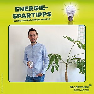 Ein Mann hält ein Energiemessgerät in der Hand.